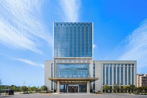 A modern hotel building with a prominent glass facade and a large entrance. - Changde Licheng Huating Hotel (Changde)