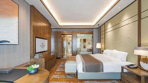 A modern hotel room with a large bed, a desk, a TV, and a bathroom visible through an open door. - Changde Licheng Huating Hotel (Changde)