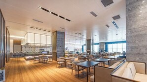 A spacious restaurant with wooden flooring, modern seating, and a large window providing natural light. - Changde Licheng Huating Hotel (Changde)