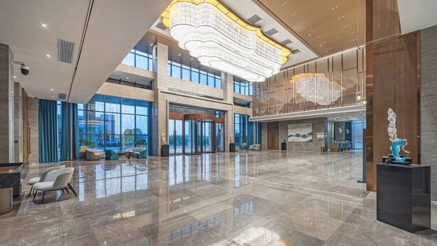 A spacious lobby with a high ceiling, large windows, and a modern chandelier. - Changde Licheng Huating Hotel (Changde)
