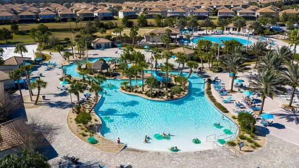 A resort with multiple swimming pools, palm trees, and lounge areas. - Modern Disney Escape - 4BR - Private Pool (Davenport)