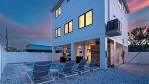 A modern two-story house with a swimming pool, outdoor seating, and a covered patio area. - 🏝️ Mod Cottage | 5 BR Home | 2 Minute Walk to the Beach | Private Pool 🌊 (Fort Myers Beach)