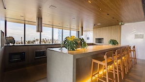 Une cuisine moderne dotée d’un grand îlot central, de tabourets de bar et offrant une vue sur la ville.