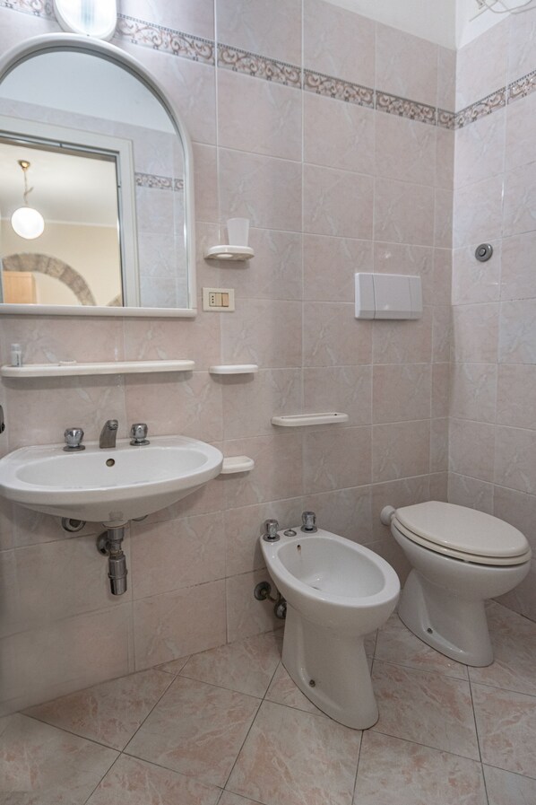 Une salle de bain équipée d’un lavabo, d’un bidet et de toilettes.