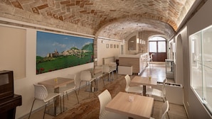 Uma área de refeições com paredes de pedra, um mural e móveis modernos.