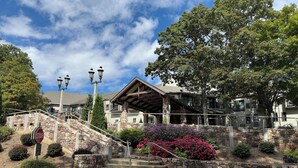 A hotel entrance with stone steps, a stop sign, and a covered porch.