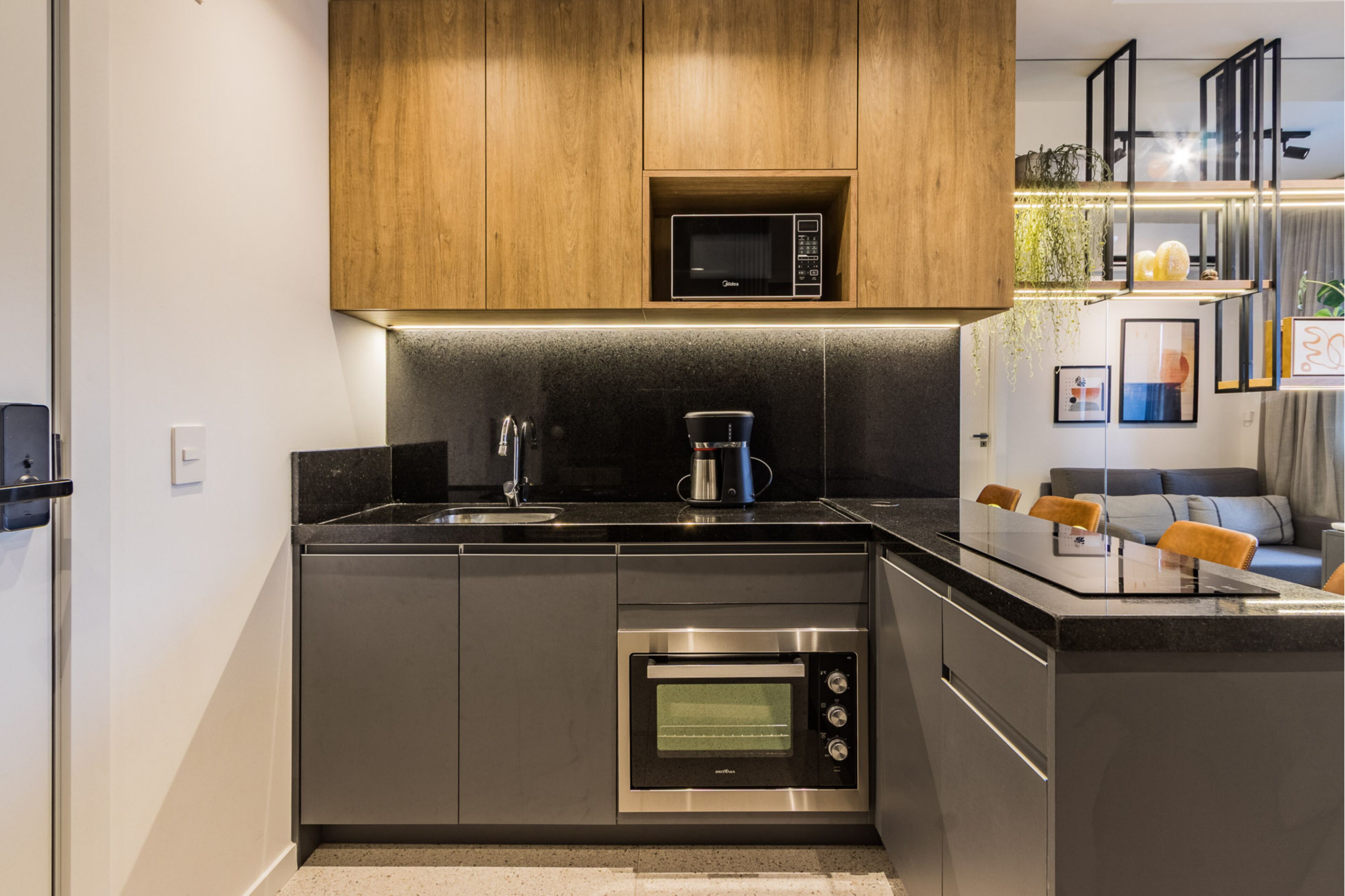 Una cocina moderna con microondas, cafetera y horno integrados.