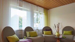 A modern living room with a sofa set, a coffee table, and a vase with plants. - Room 'Nr 1' with Shared Terrace and Shared Garden (Dachsberg)