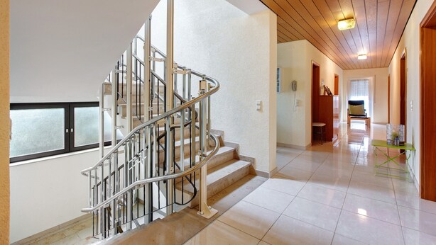 A modern interior with a spiral staircase, a hallway with a bench, and a wooden ceiling. - Room 'No. 7' with Shared Terrace and Shared Garden (Dachsberg)