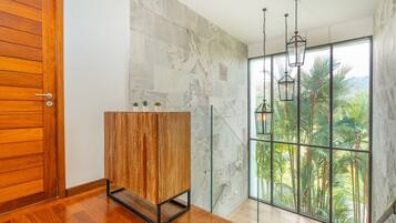 A modern room with a wooden door, a wooden cabinet, and a large window with a view of palm trees.