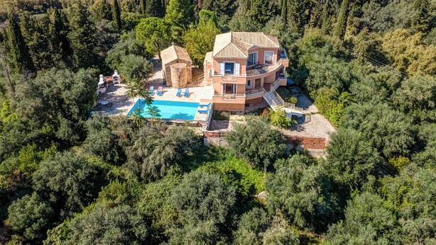 Ein mehrstöckiges Haus mit Schwimmbad, umgeben von dichtem Wald.