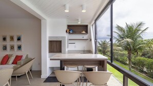 Una cucina moderna con una grande isola, scaffali a incasso e vista su palme.