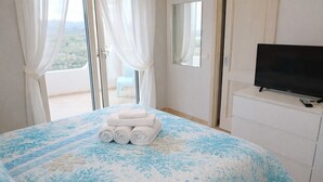 Ein Hotelzimmer mit Bett, Fernseher auf einem Schminktisch und Blick durch das Fenster.