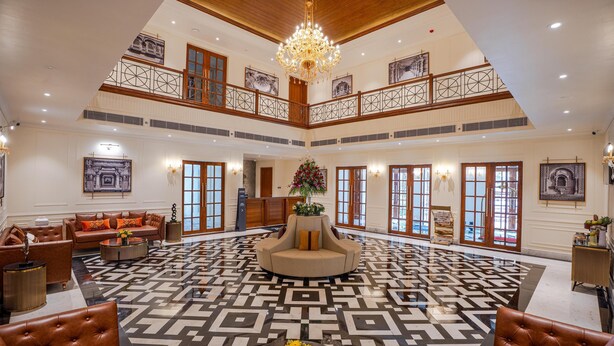 A spacious lobby with a geometric patterned floor, a central seating area, and a chandelier. - Radisson Resort Mount Abu (Mount Abu)