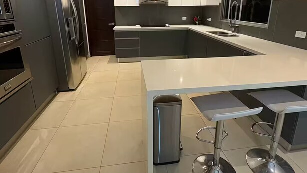 A modern kitchen with a large island, stainless steel appliances, and a minimalist design. - Tropical Getaway in Heredia, Costa Rica (Heredia)