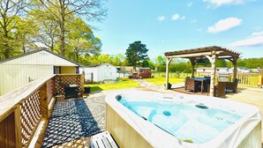 A backyard with a hot tub, wooden deck, and a pergola. - 4BD | 3BTH | Pool | HotTub | Games |5Miles to I-95 (Elloree)