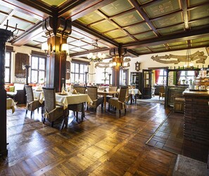 A spacious dining area with wooden flooring and high ceilings, featuring tables and chairs arranged for dining. - Family-Friendly Hotel in the Heart of the City (Rüdesheim am Rhein)