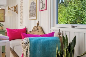 A bedroom with a bed, pillows, a window, and wall decorations.