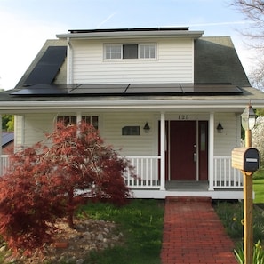 A two-story house with a front porch, a mailbox, and a number '125' on the door.