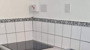 Zona de lavandería con lavadora, tendedero y lavabo.