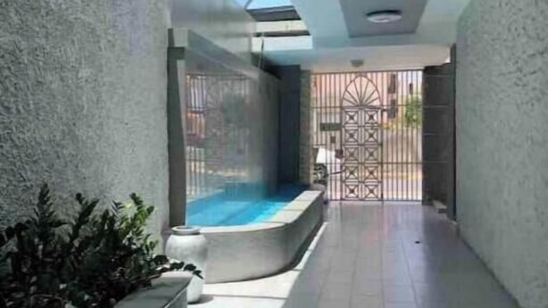 A corridor with a pool area, a skylight, and a gated entrance. - Sofia’s Beach Apartment (Carolina)