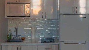 Une cuisine moderne équipée d’appareils électroménagers en acier inoxydable, d’un four encastré et d’un four à micro-ondes.