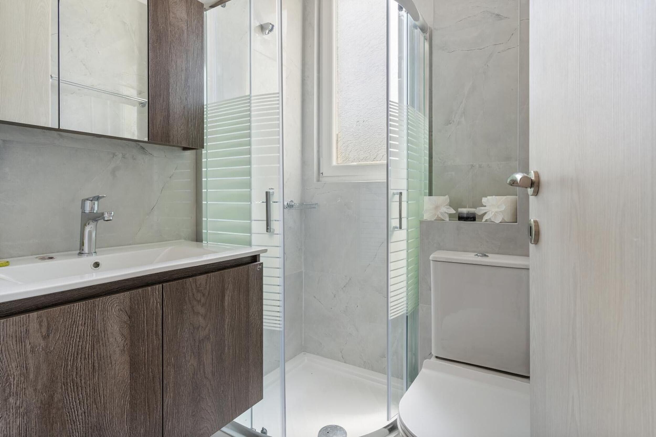 A bathroom with a shower, toilet, and sink.