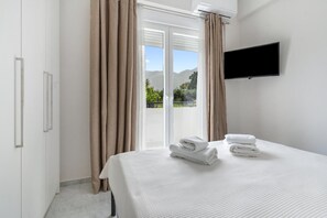 Une chambre d’hôtel avec un lit, une télévision et une vue sur l’extérieur.