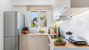A modern kitchen with a built-in refrigerator, a sink, and a window with a view of the outside.