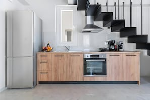 A modern kitchen with a stainless steel refrigerator, wooden cabinets, a built-in oven, and a coffee maker. - Apartment 'Miralis' with Mountain View, Wi-Fi and Air Conditioning (Nikiana)