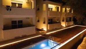 Un edificio moderno con varios balcones y una piscina.