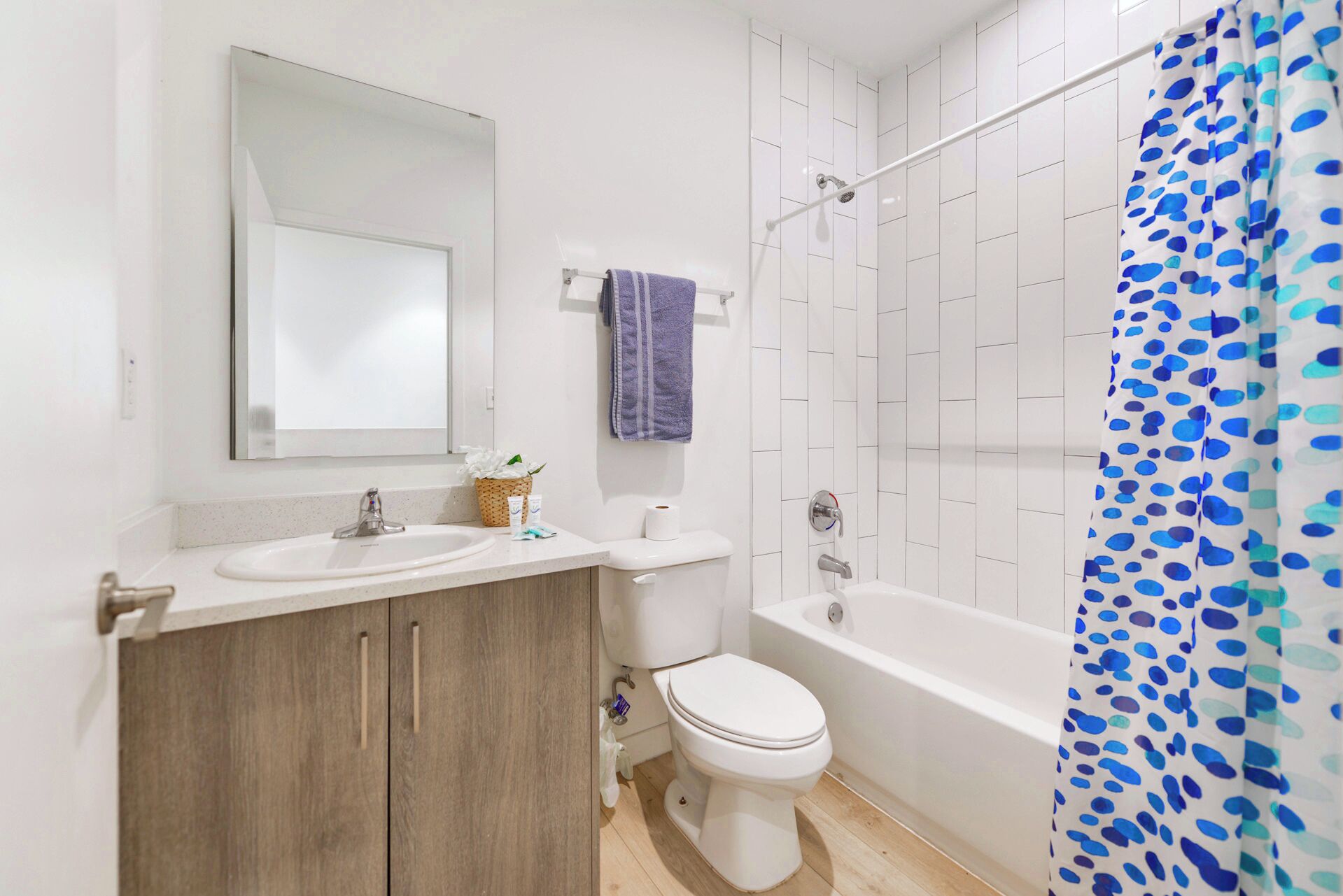 A bathroom with a sink, mirror, toilet, and bathtub.