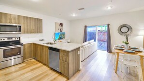 Une cuisine moderne avec des armoires en bois, des appareils en acier inoxydable et un grand îlot central.