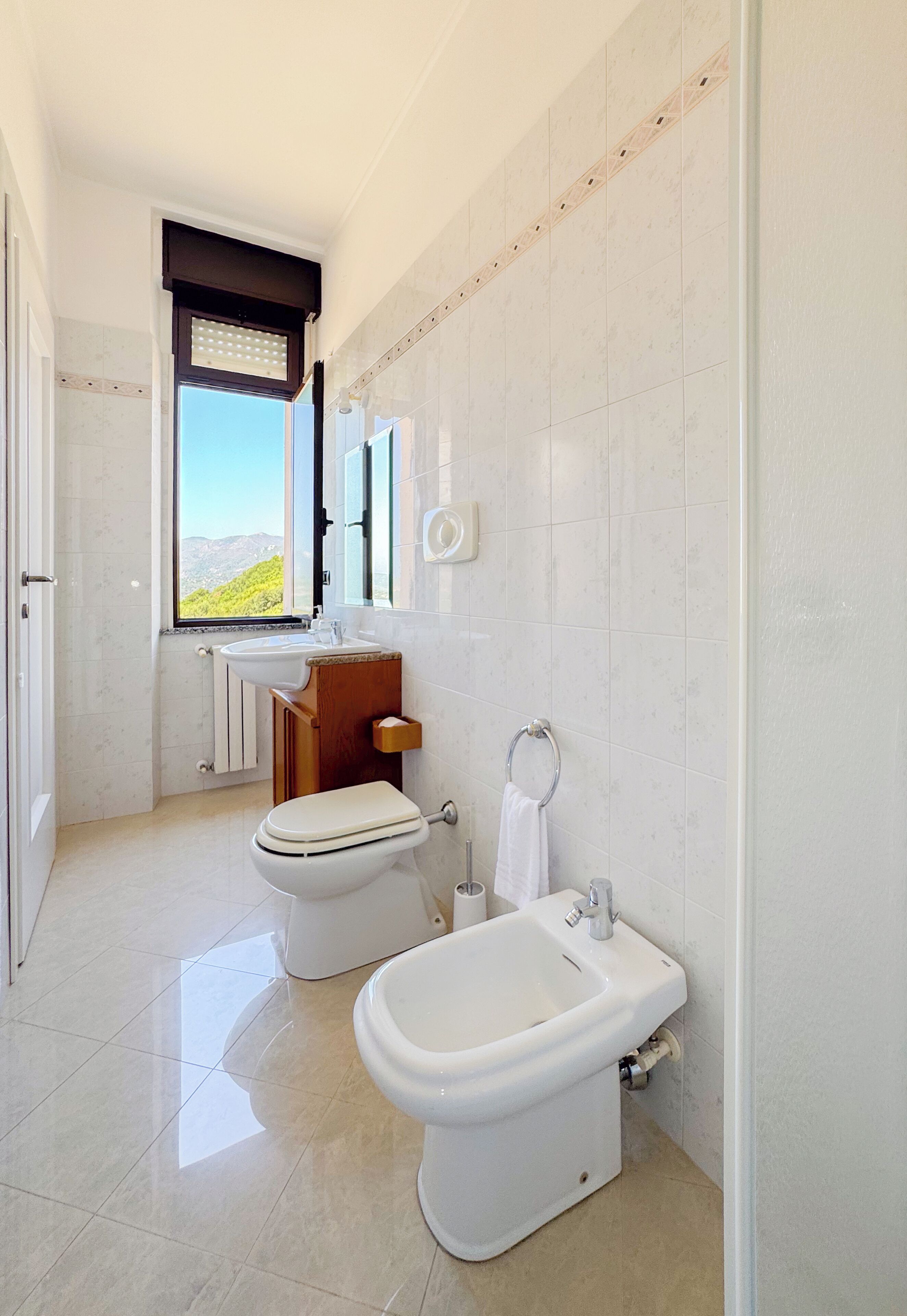 A modern bathroom with a toilet, bidet, and sink.