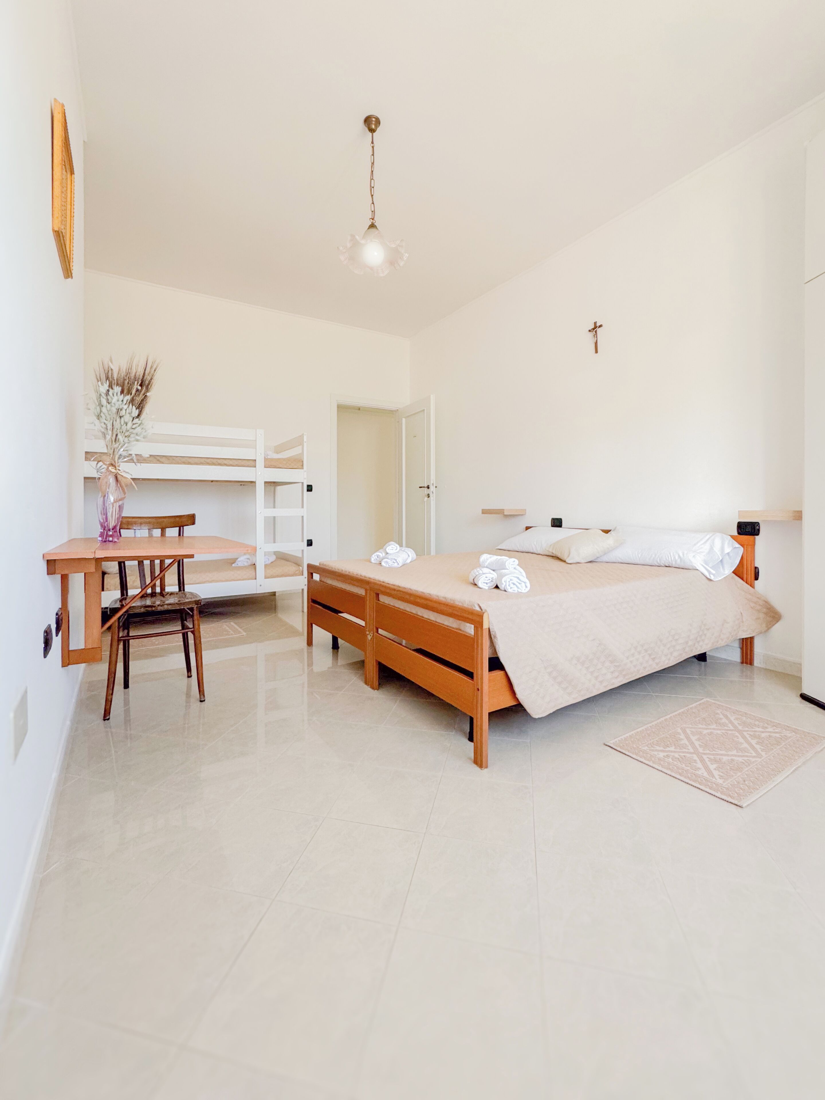 Une chambre à coucher avec un lit, des tables de chevet, un bureau et une chaise.
