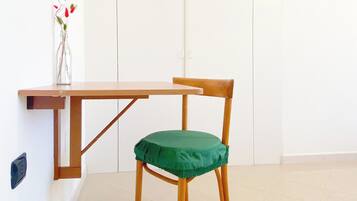 Een kamer met een houten tafel en een groene fauteuil.