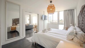 A modern hotel room with a large bed, a television, and a large mirror.
