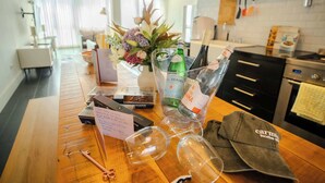 A wooden table with wine glasses, a bottle of champagne, a cap, and a menu.