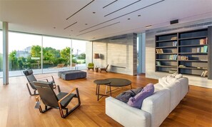 A modern living room with a sofa, chairs, a coffee table, and a bookshelf. - Carmelo  Treasure Villa (Herzliya)