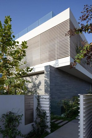 A modern building with a flat roof, large windows, and a minimalist design.