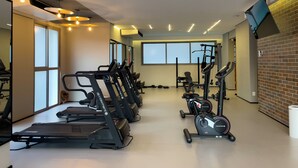 Un gimnasio con cintas de correr, elípticas y equipo de pesas.
