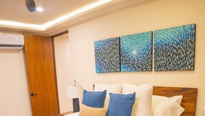 A bedroom with a bed, bedside tables, a bench, and artwork on the wall. - Cozumel NEW Siesta Studio: 1BR/Wi-Fi/AC/Noise Proof/With View (Cozumel)