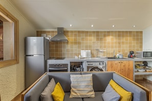 Cocina compacta con refrigerador, horno, microondas y lavadora.