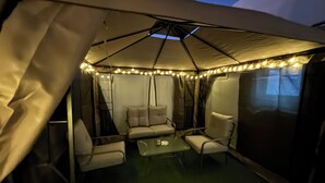 A tented outdoor seating area with a table and chairs, string lights, and a canopy. - Cozy room in lovely with side yard in Riyadh with WiF (Riyadh)