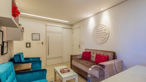 Een moderne woonkamer met een bank, een salontafel en een transparante stoel.