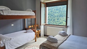 A bunk bed room with a view of a forest through a window. - Casa Priula (Albaredo per San Marco)