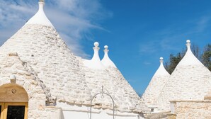 A building with multiple conical roofs and a stone facade. - Trulli Isabella by Wonderful Italy (Ceglie Messapica)