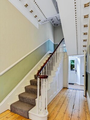 A staircase with white railings and a wooden handrail, leading to a door with a glass panel. - Fabulous 6 Bedroom Victorian Period House (Londonderry)