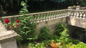 A garden with a stone balustrade, various plants, and a concrete wall. - Fabulous 6 Bedroom Victorian Period House (Londonderry)