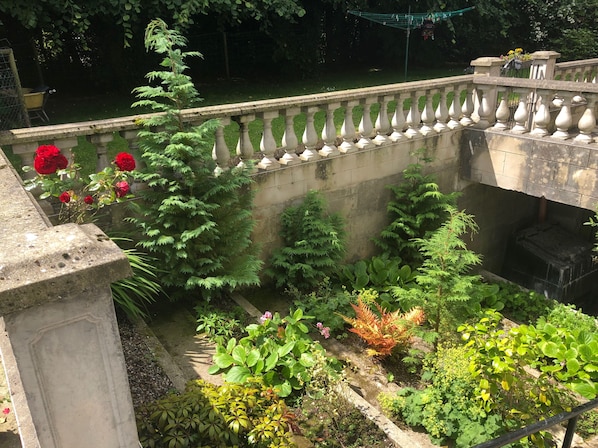 A garden with a stone balustrade, various plants, and a concrete wall. - Fabulous 6 Bedroom Victorian Period House (Londonderry)